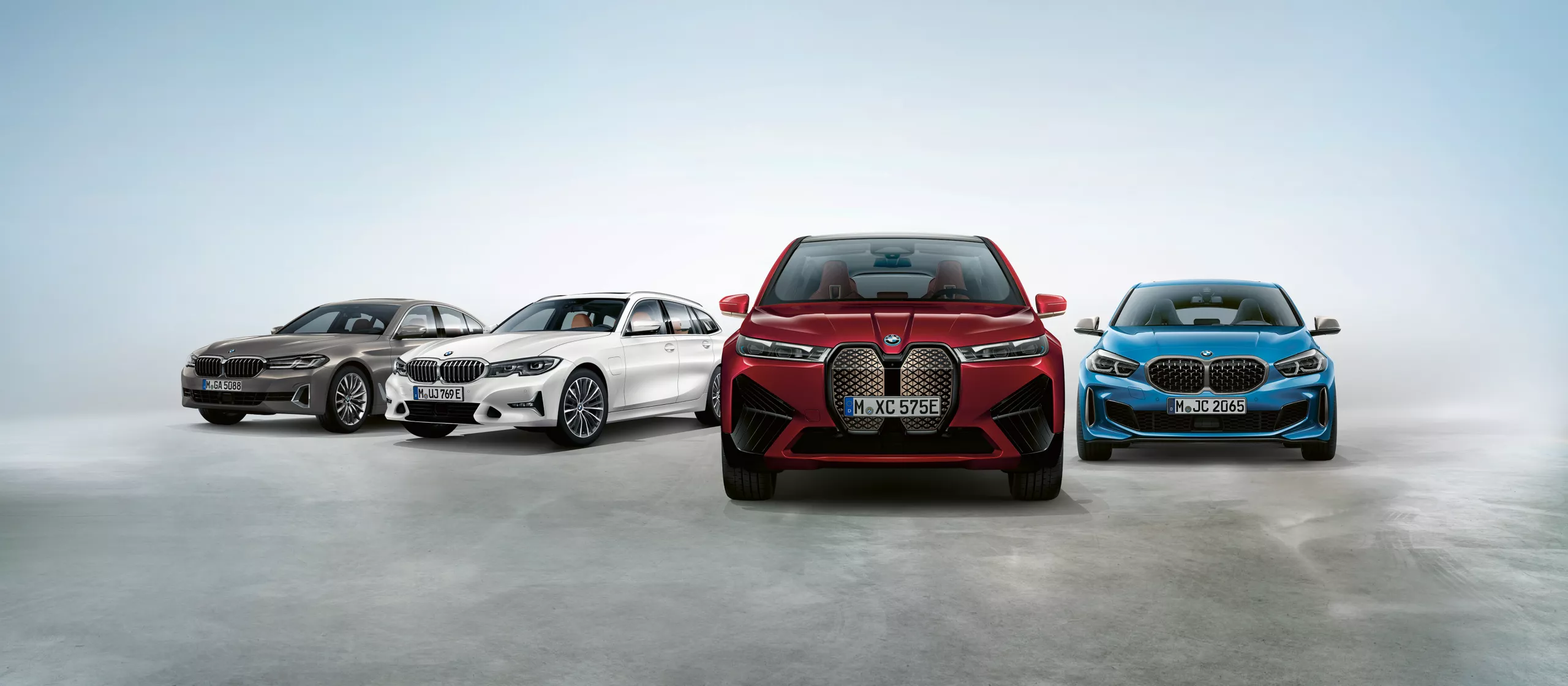 BMW Müller EUROPLUS GARANTIE. Vier neue BMW Modelle verschiedener Farben und Typen in einem Studio.
