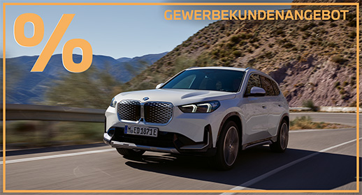 Das Bild zeigt eine Werbegrafik für ein Fahrzeugangebot. In der Mitte fährt ein weißer BMW iX1 (ein kompakter Elektro-SUV) auf einer geschwungenen Bergstraße. Das Auto ist in einer dynamischen Dreiviertelansicht von vorne zu sehen, während im Hintergrund eine sonnige, karge Berglandschaft unter blauem Himmel vorbeizieht.  Der gesamte Bildinhalt wird von einem dünnen orangefarbenen Rahmen umschlossen. In der oberen linken Ecke prangt ein sehr großes, auffälliges Prozentzeichen (%) in hellem Orange. Oben rechts steht in serifenloser, orangefarbener Großschrift das Wort „GEWERBEKUNDENANGEBOT“. Das Bild vermittelt einen modernen, professionellen Eindruck und richtet sich gezielt an Geschäftskunden.