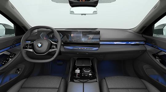 BMW 520i Limousine Innenraum Ausstattung Innenansicht des Cockpits einer BMW Limousine mit digitalem Kombiinstrument, großem Infotainment-Display, Lenkrad und blauer Ambientebeleuchtung im Armaturenbrett und Fußraum. Das Bild zeigt den modernen Innenraum des Fahrzeugs.