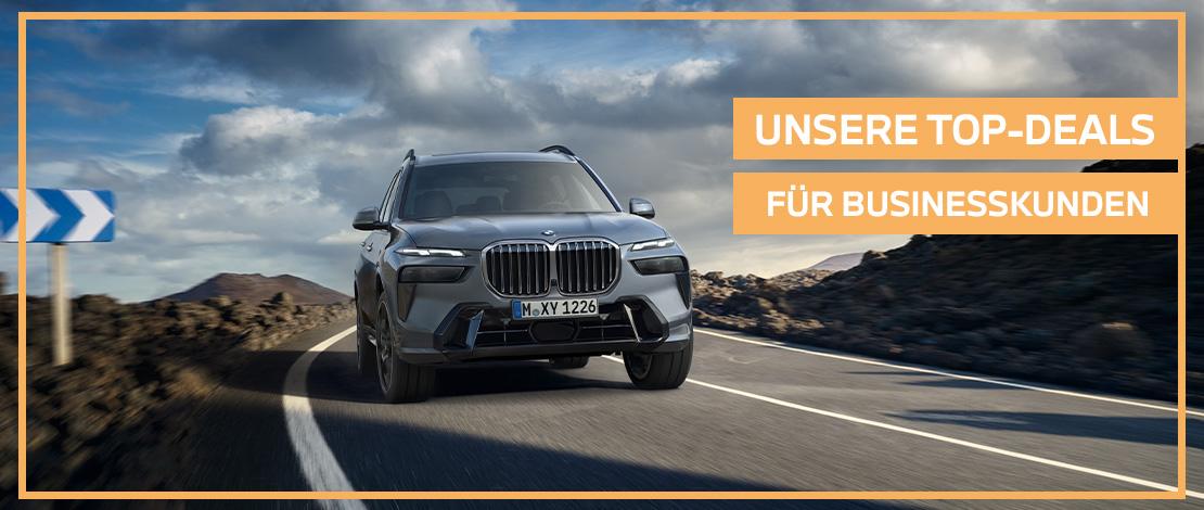 Das Bild zeigt einen grauen BMW X7, der auf einer Straße fährt. Auf der rechten Seite des Bildes steht in großen Buchstaben „UNSERE TOP-DEALS FÜR BUSINESSKUNDEN“. Das gesamte Bild hat einen orangefarbenen Rahmen.