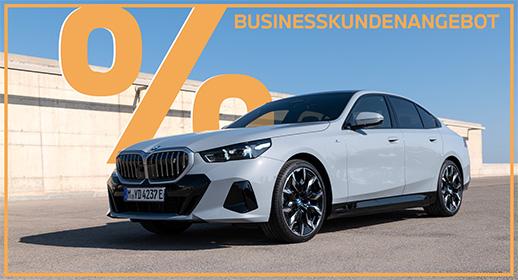  Das Bild zeigt eine hellgraue BMW i5 Limousine auf einer gepflasterten Fläche. Im oberen Teil steht der Text „BUSINESSKUNDENANGEBOT“, und links ist ein großes, oranges Prozentsymbol zu sehen. Ein orangefarbener Rahmen umgibt das gesamte Bild.